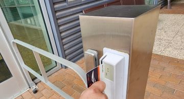 Student swiping their student ID at the entrance of a door.
