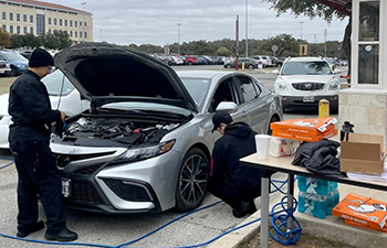 Valvoline checking a students car.