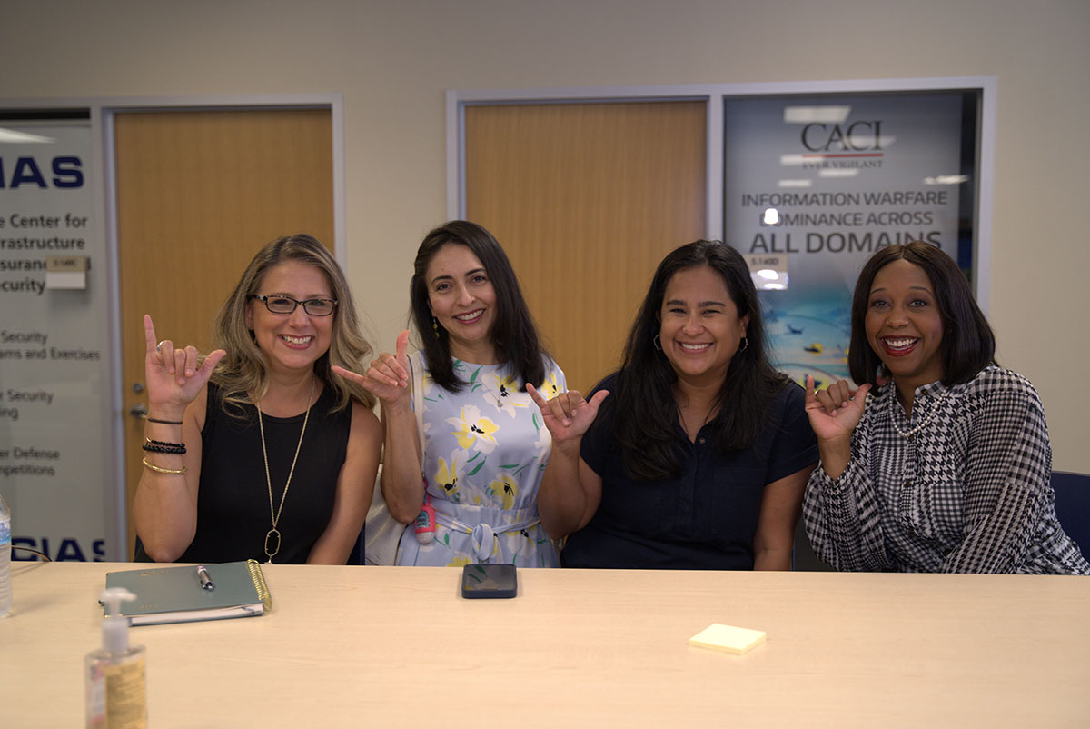 Alumni and Advancement employees giving birds up and smiling