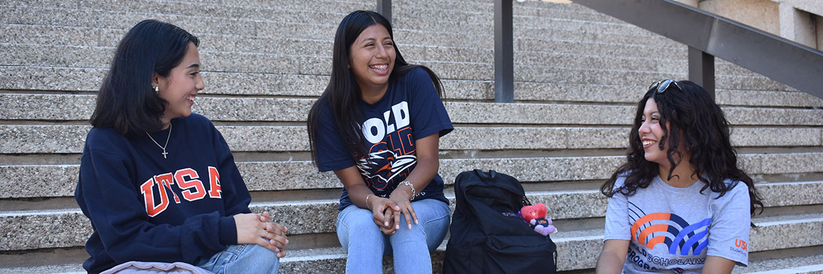 Two students outside smiling and talking