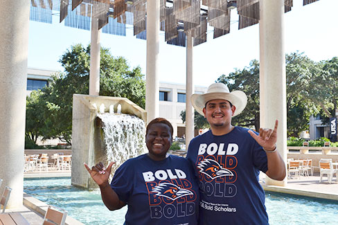 Two students at the paseo with bold scholars shirts
