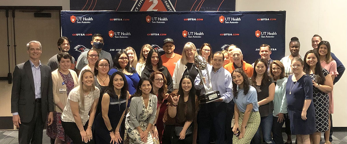 BRAVING Champions members holding UTSA trophy and giving birds up