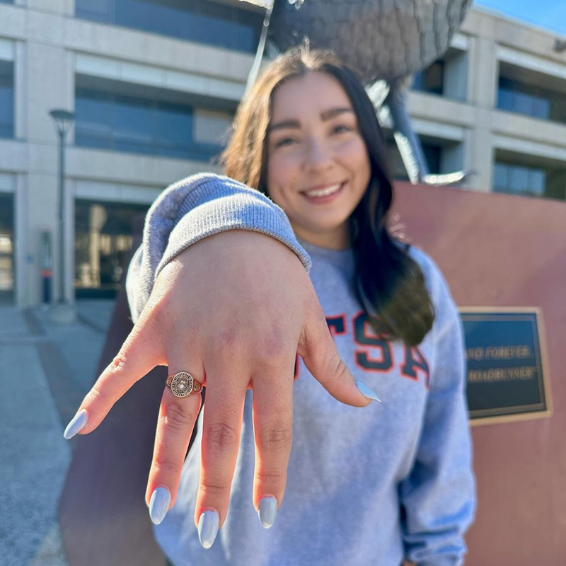 Student showing off UTSA ring roadrunner statue