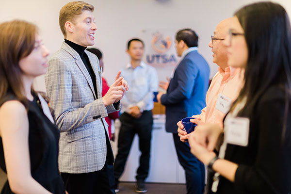 Students and staff speaking at a College of Business networking event