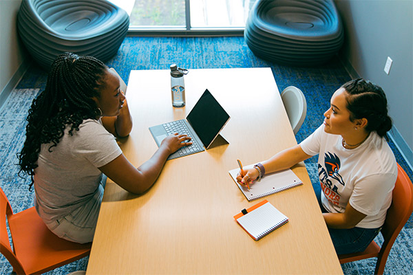 Two students talking at a table