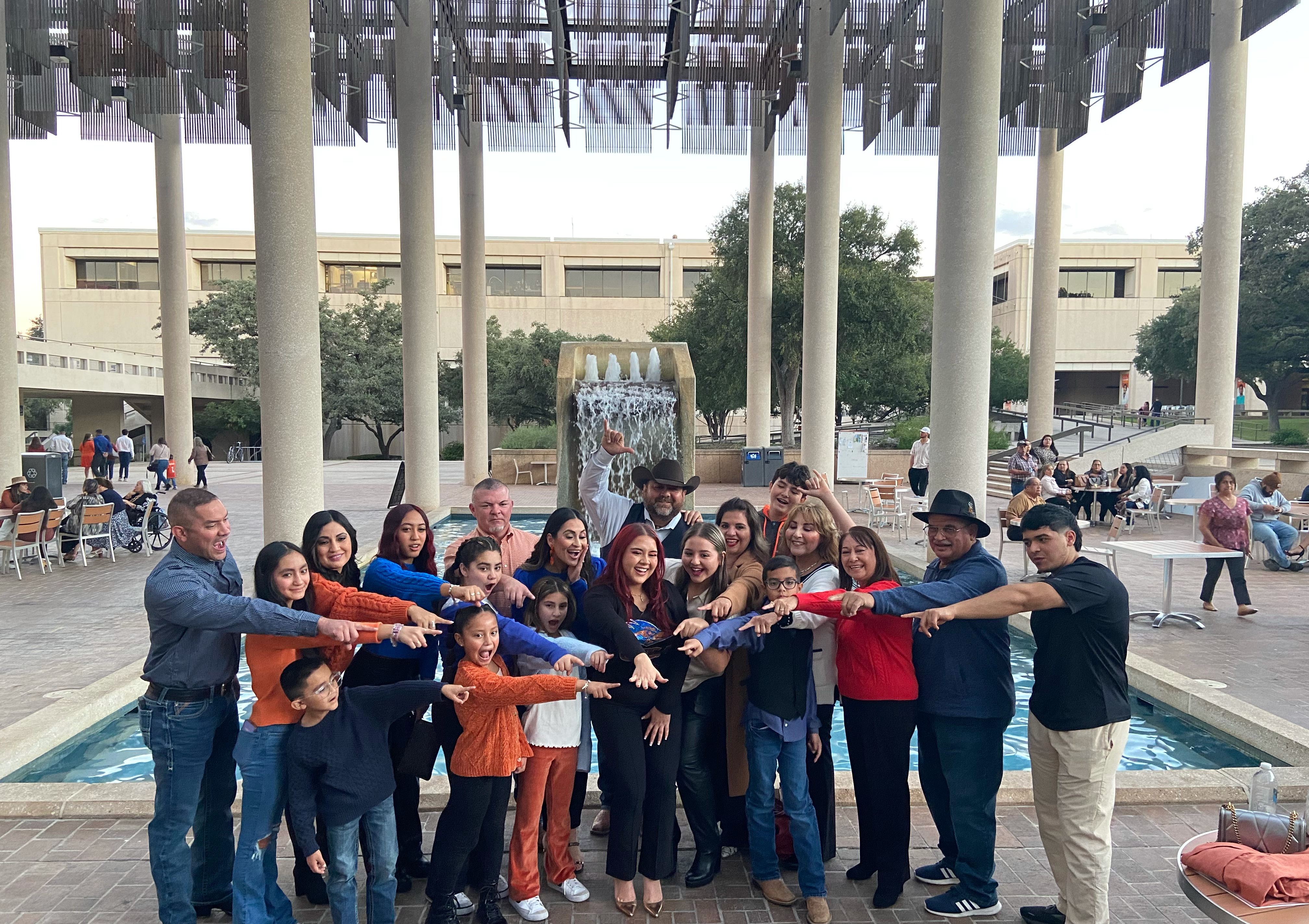 family pointing at ut san antonio student's ring on her finger