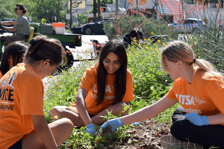 Group of students wearing light blue t-shirts with 'UTSA Volunteers' on it