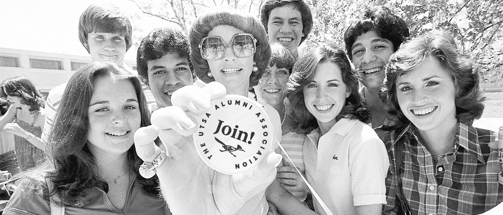 70's photo of Students holding button that states join UTSA alumni association