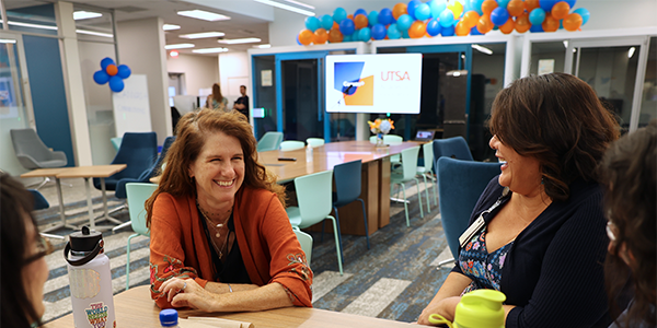 Terri Matiella speaking to others at a table