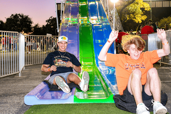 two students coming down the slide